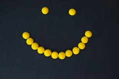 Sourire de dragée jaune de sucreries sur un fond noir photo libre de droits Sourire de dragée jaune de sucreries sur un fond noir photo libre de droits
