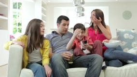 Spaanse Familiezitting op Sofa Watching-TV samen stock videobeelden Spaanse Familiezitting op Sofa Watching-TV samen stock videobeelden