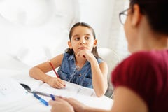 Spaanse Moeder die Meisje helpen die Schoolthuiswerk thuis doen royalty-vrije stock afbeelding Spaanse Moeder die Meisje helpen die Schoolthuiswerk thuis doen royalty-vrije stock afbeelding