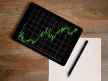 Space Grey Ipad Air With Graph on Brown Wooden Table royalty free stock images Space Grey Ipad Air With Graph on Brown Wooden Table royalty free stock images