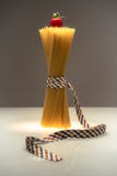 Spaghetti emball?s de mode attach?s avec le ruban sur le fond bicolore avec la tomate sur le dessus photo libre de droits Spaghetti emball?s de mode attach?s avec le ruban sur le fond bicolore avec la tomate sur le dessus photo libre de droits