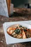 Spaghetti van het Stootkussenkapraw van fusiedeegwaren de kruidige Thaise met knoflook, rode Spaanse pepers, garnalen en heilig b royalty-vrije stock afbeelding Spaghetti van het Stootkussenkapraw van fusiedeegwaren de kruidige Thaise met knoflook, rode Spaanse pepers, garnalen en heilig b royalty-vrije stock afbeelding