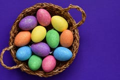 Sparkling glittering colored candy Easter eggs in a wicker basket, top view royalty free stock images Sparkling glittering colored candy Easter eggs in a wicker basket, top view royalty free stock images