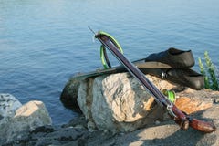Spearfishing przekładnia - żebra, speargun na morze skale przeciw błękitnemu s obraz stock Spearfishing przekładnia - żebra, speargun na morze skale przeciw błękitnemu s obraz stock