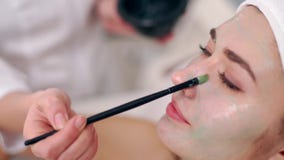 Specialista di cosmetologia che applica maschera facciale facendo uso della spazzola, facendo pelle idratata e sana donna di dist video d archivio Specialista di cosmetologia che applica maschera facciale facendo uso della spazzola, facendo pelle idratata e sana donna di dist video d archivio