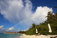 Spectaculaire regenboog op wit Maldivian strand in de hemel met gekleurde wolken bij zonsondergang stock foto Spectaculaire regenboog op wit Maldivian strand in de hemel met gekleurde wolken bij zonsondergang stock foto