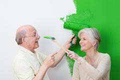 Speels hoger paar die hun groen huis schilderen stock afbeeldingen Speels hoger paar die hun groen huis schilderen stock afbeeldingen