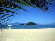 Spiaggia brasiliana con una presidenza e un'isola fotografie stock Spiaggia brasiliana con una presidenza e un'isola fotografie stock