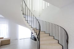 Spiral staircase in bright interior with white brick wall in elite expensive apartment stock photo Spiral staircase in bright interior with white brick wall in elite expensive apartment stock photo