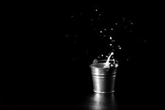 Splash in metal bucket with milk on black background royalty free stock image Splash in metal bucket with milk on black background royalty free stock image