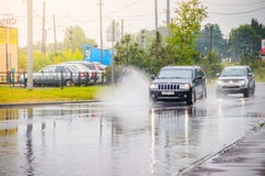 Splashing water on the road from the car. Summer rain. Puddles on the road. Russian roads. Wet street. Russia, Leningrad region stock images Splashing water on the road from the car. Summer rain. Puddles on the road. Russian roads. Wet street. Russia, Leningrad region stock images