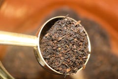 Spooning loose tea leafs out of a container - selective focus royalty free stock photography Spooning loose tea leafs out of a container - selective focus royalty free stock photography