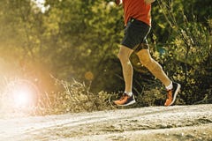Sport man with ripped athletic and muscular legs running downhill off road in jogging training workout stock photo Sport man with ripped athletic and muscular legs running downhill off road in jogging training workout stock photo