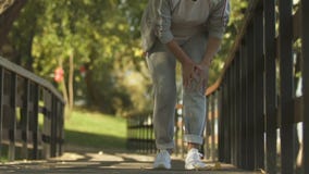 Sport woman feeling sudden knee pain while jogging park, osteoarthritis symptom