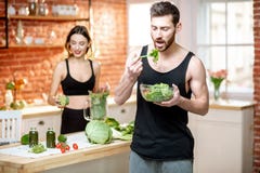 Sportenpaar die gezond vegetarisch voedsel op de keuken eten royalty-vrije stock foto's Sportenpaar die gezond vegetarisch voedsel op de keuken eten royalty-vrije stock foto's