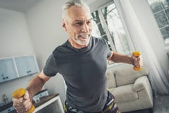 Sportivo sorridente che porta camicia grigia che tiene le teste di legno fotografie stock libere da diritti Sportivo sorridente che porta camicia grigia che tiene le teste di legno fotografie stock libere da diritti