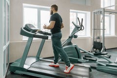 Sportowy mięśniowy brodaty mężczyzny bieg na karuzelach w nowożytnym sporta gym Sprawność fizyczna, sport, szkolenie, ludzie poję obraz stock Sportowy mięśniowy brodaty mężczyzny bieg na karuzelach w nowożytnym sporta gym Sprawność fizyczna, sport, szkolenie, ludzie poję obraz stock