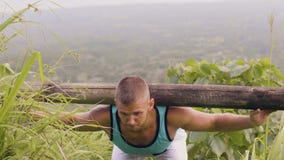 Sportsman training good morning exercise with heavy timber barbell on shoulders outdoor. Fitness man using wooden timber stock video footage Sportsman training good morning exercise with heavy timber barbell on shoulders outdoor. Fitness man using wooden timber stock video footage