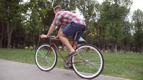 Sporty guy cycling at the park road. Young handsome man riding a vintage bicycle outdoor. Healthy active lifestyle. Side Royalty Free Stock Photo Sporty guy cycling at the park road. Young handsome man riding a vintage bicycle outdoor. Healthy active lifestyle. Side Royalty Free Stock Photo