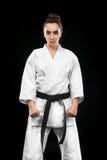 Sporty karate i Taekwondo kobieta w białym kimonie z czarnym paskiem na ciemnym tle Sporta pojęcie z kopii przestrzenią zdjęcie stock Sporty karate i Taekwondo kobieta w białym kimonie z czarnym paskiem na ciemnym tle Sporta pojęcie z kopii przestrzenią zdjęcie stock