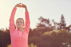 Sporty senior woman doing exercise warm-up stretches outdoors stock photo Sporty senior woman doing exercise warm-up stretches outdoors stock photo