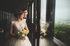 Sposo e sposa con una condizione del mazzo sul terrazzo con la vista verde della natura immagini stock Sposo e sposa con una condizione del mazzo sul terrazzo con la vista verde della natura immagini stock