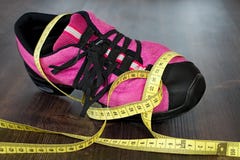 Sprawność fizyczna buty i pomiarowa taśma na pokładzie zdjęcia stock Sprawność fizyczna buty i pomiarowa taśma na pokładzie zdjęcia stock