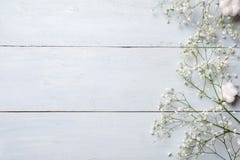 Spring background. White rustic flowers on blue wooden table. Banner mockup for womans or mother day, happy easter, spring holiday