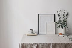 Spring, Easter breakfast still life. Cup of coffee, books and empty picture frames mockups. Linen tablecloth. Olive tree