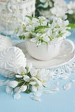 Spring flowers background with tea cup and sweet cookies