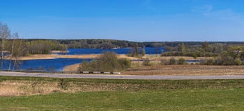 Spring panorama with the blue lake, island, sky and forest on th royalty free stock image Spring panorama with the blue lake, island, sky and forest on th royalty free stock image
