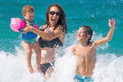 Spruzzata dell'acqua di divertimento del mare di estate della famiglia Spruzzata dell'acqua di divertimento del mare di estate della famiglia