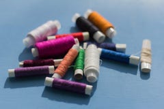 Spulen des farbigen Threads auf einem blauen Hintergrund lizenzfreie stockbilder Spulen des farbigen Threads auf einem blauen Hintergrund lizenzfreie stockbilder
