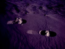 Spårar av mänskliga ben på en härlig ultraviolett snötextur arkivfoto Spårar av mänskliga ben på en härlig ultraviolett snötextur arkivfoto