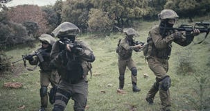 Squad of fully armed commando soldiers during combat in a forest scenery stock video Squad of fully armed commando soldiers during combat in a forest scenery stock video