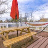 Square frame Wooden patio with white railing overlooking the yard and cloudy blue sky royalty free stock image Square frame Wooden patio with white railing overlooking the yard and cloudy blue sky royalty free stock image