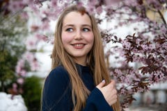 St?ende av den h?rliga blonda flickan som poserar, i att blomma tr?dfilialer med rosa blommor rockera den cesky fj?dern f?r arvkr arkivbilder St?ende av den h?rliga blonda flickan som poserar, i att blomma tr?dfilialer med rosa blommor rockera den cesky fj?dern f?r arvkr arkivbilder