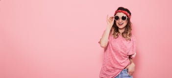 St?ende av hipsterflickan i exponeringsglas p? rosa bakgrund royaltyfria foton St?ende av hipsterflickan i exponeringsglas p? rosa bakgrund royaltyfria foton