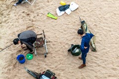 St. Petersburg, Russia - July 10, 2018: Group of fishermen are fishing on the sandy shores of the Gulf of Finland under the bridge royalty free stock images St. Petersburg, Russia - July 10, 2018: Group of fishermen are fishing on the sandy shores of the Gulf of Finland under the bridge royalty free stock images