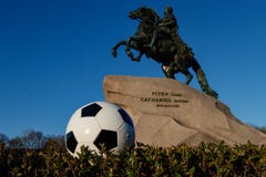 St Petersburg. Russia, May 9, 2018: Concept for the World Cup in Russia. A soccer ball against the background of a brass rider. M stock photos St Petersburg. Russia, May 9, 2018: Concept for the World Cup in Russia. A soccer ball against the background of a brass rider. M stock photos