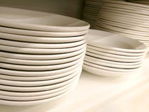 Stack of new clean white plain plates and bowls on the shelf royalty free stock photography Stack of new clean white plain plates and bowls on the shelf royalty free stock photography