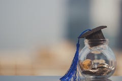 Staffelungshut auf Münzengeld in der Glasflasche auf weißem Hintergrund lizenzfreies stockbild Staffelungshut auf Münzengeld in der Glasflasche auf weißem Hintergrund lizenzfreies stockbild