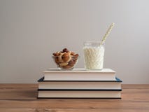 Stapel Bücher mit Nüssen und einem Glas Milch stockfotos Stapel Bücher mit Nüssen und einem Glas Milch stockfotos