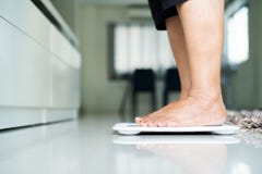 Starej kobiety pozycja na ciężar skala w żywym pokoju obrazy stock Starej kobiety pozycja na ciężar skala w żywym pokoju obrazy stock