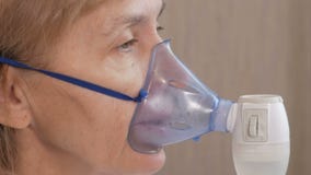 Starsza kobieta trzyma maskę od inhalatoru w domu Taktuje rozognienie drogi oddechowe przez nebulizer Zapobiegać astmę zbiory wideo Starsza kobieta trzyma maskę od inhalatoru w domu Taktuje rozognienie drogi oddechowe przez nebulizer Zapobiegać astmę zbiory wideo