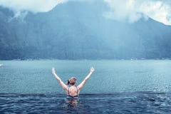 Starsza kobieta w natura pływackim basenie z zadziwiającym halnym tłem Tropikalna wyspa Bali, Indonezja obrazy stock Starsza kobieta w natura pływackim basenie z zadziwiającym halnym tłem Tropikalna wyspa Bali, Indonezja obrazy stock