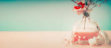 Station thermale ou fond de bien-être avec la bouteille et les fleurs de parfum de pièce sur le fond en pastel, vue de face Photos stock Station thermale ou fond de bien-être avec la bouteille et les fleurs de parfum de pièce sur le fond en pastel, vue de face Photos stock