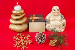 Statyett av en skratta Buddha Hotei med stenar och en stearinljus, snöflinga och bula, såväl som en gåvaask och ett kort med fri arkivfoton Statyett av en skratta Buddha Hotei med stenar och en stearinljus, snöflinga och bula, såväl som en gåvaask och ett kort med fri arkivfoton