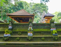 Statyn i den hinduiska templet i den Ubud apaskogen som täckas av mossa, Bali ö, Indonesien royaltyfria bilder Statyn i den hinduiska templet i den Ubud apaskogen som täckas av mossa, Bali ö, Indonesien royaltyfria bilder
