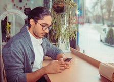 Staying connected. Happy young man looking at his mobile phone stock images Staying connected. Happy young man looking at his mobile phone stock images